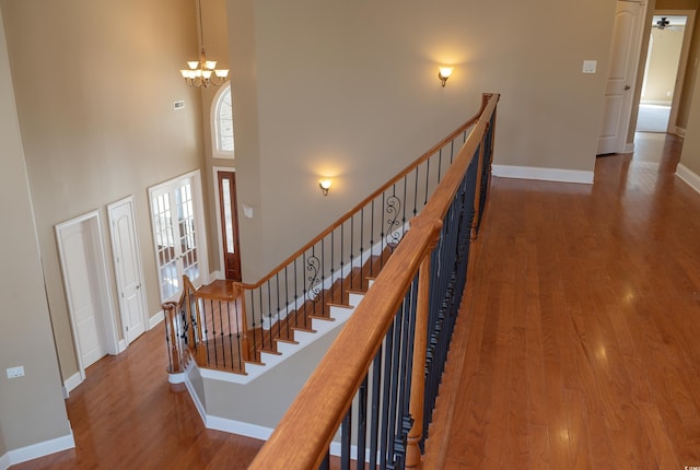 interior space with a high ceiling, baseboards, and wood finished floors