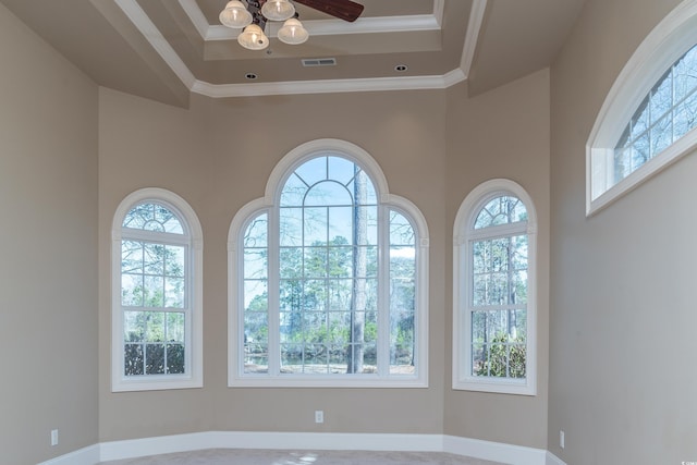 unfurnished room with a wealth of natural light, crown molding, visible vents, and a tray ceiling