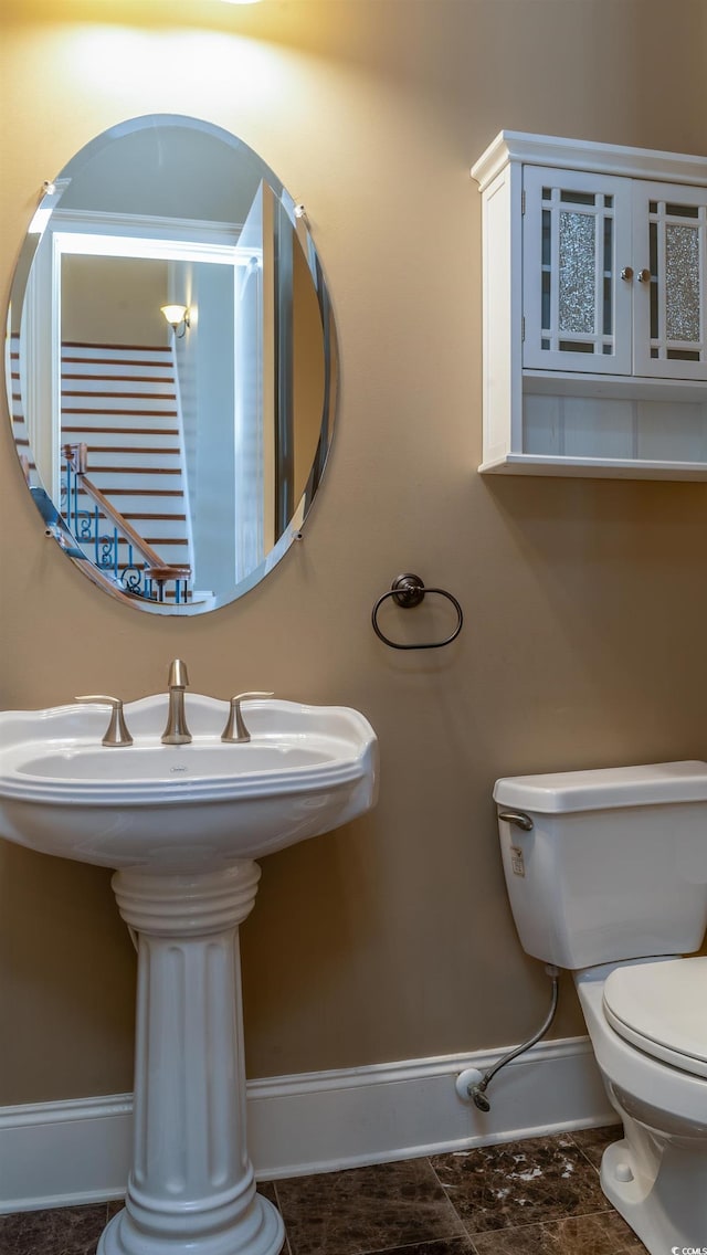 bathroom featuring toilet and baseboards