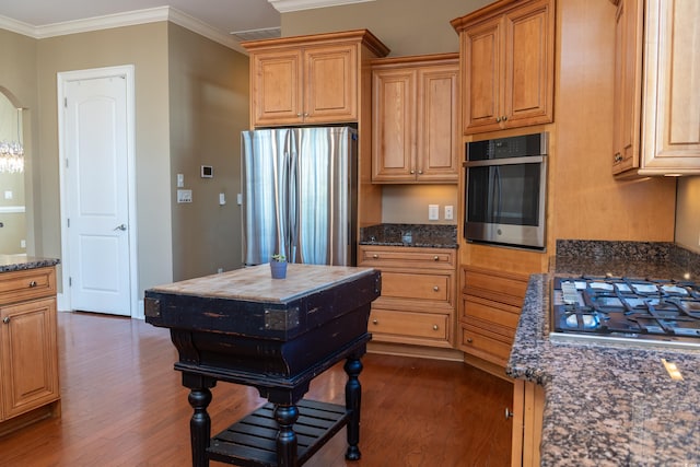 kitchen featuring stainless steel appliances, arched walkways, dark stone counters, and dark wood-type flooring