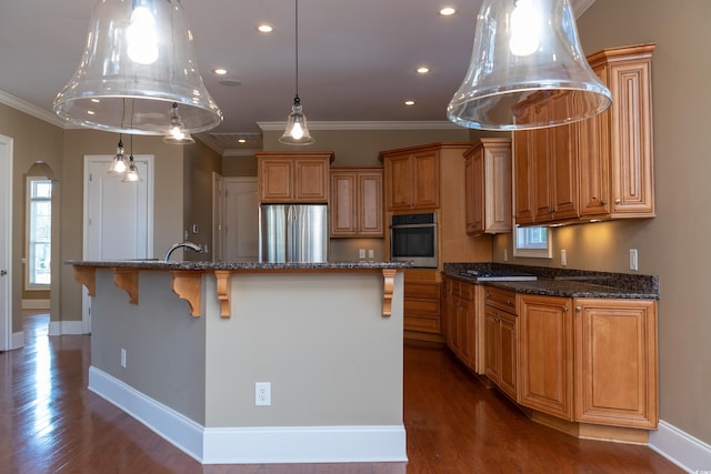 kitchen featuring stainless steel appliances, brown cabinetry, and a spacious island