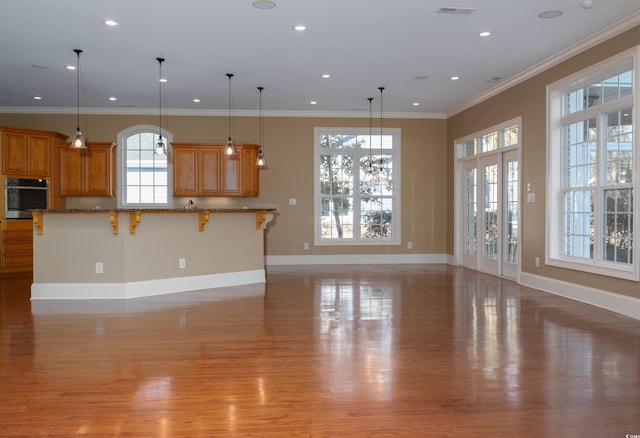 unfurnished living room featuring recessed lighting, crown molding, light wood-style flooring, and baseboards