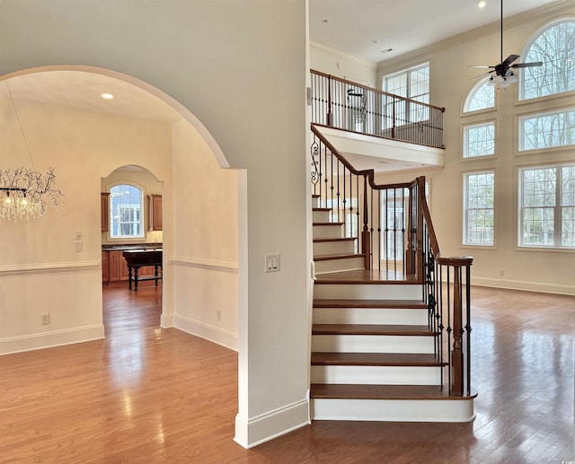 stairway with a wealth of natural light and wood finished floors