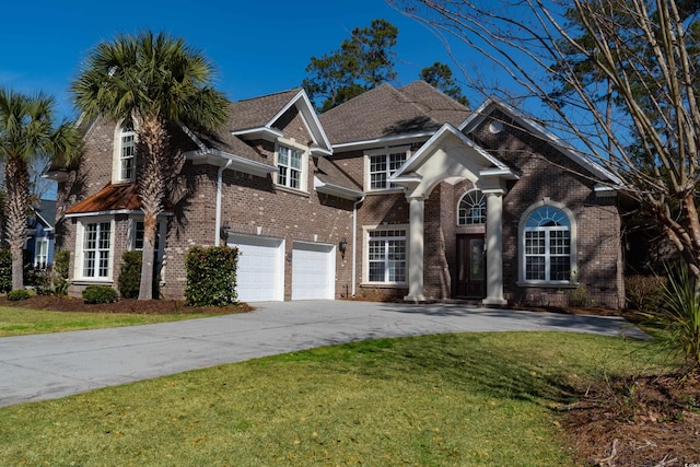 view of front of house with concrete driveway, a front lawn, an attached garage, and brick siding