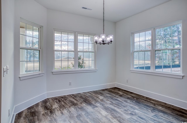 unfurnished dining area featuring dark hardwood / wood-style flooring and a chandelier