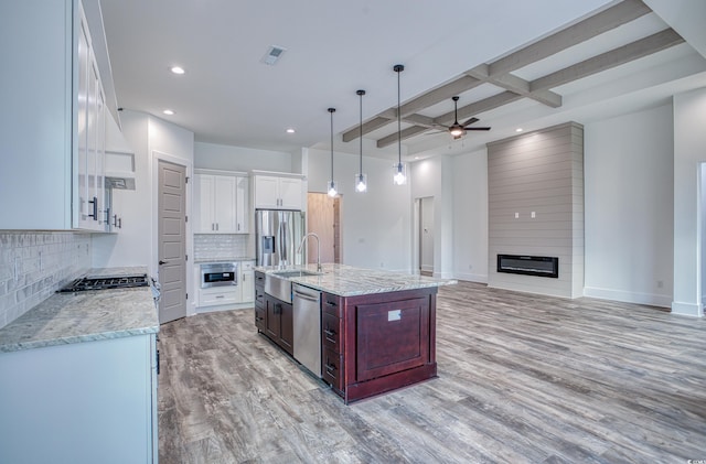 kitchen with appliances with stainless steel finishes, white cabinets, tasteful backsplash, beam ceiling, and coffered ceiling