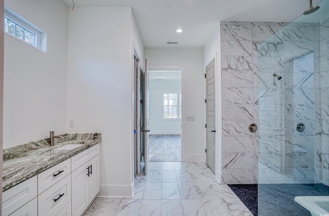 bathroom featuring a tile shower, a healthy amount of sunlight, and vanity