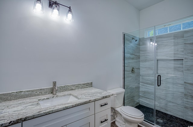 bathroom with toilet, vanity, and an enclosed shower