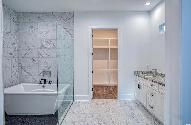 bathroom featuring vanity, tile walls, and a bath