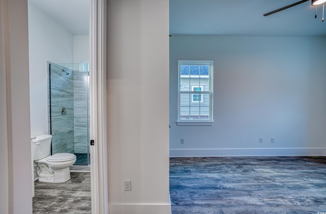 bathroom with ceiling fan, hardwood / wood-style flooring, toilet, and tiled shower