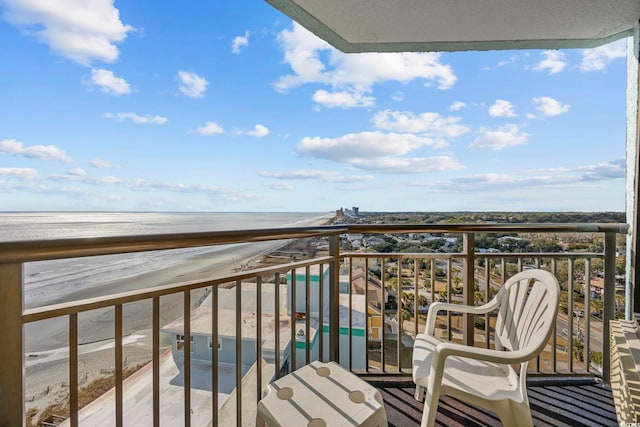 balcony with a water view and a view of the beach