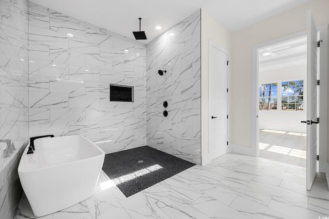 bathroom with marble finish floor, a freestanding tub, a sink, and walk in shower