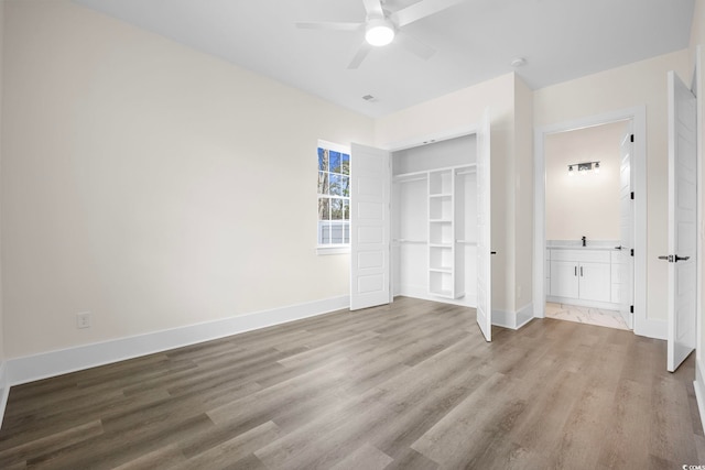 unfurnished bedroom with baseboards, a closet, a ceiling fan, and light wood-style floors