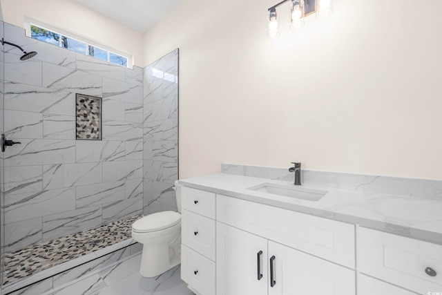 full bathroom featuring toilet, marble finish floor, a marble finish shower, and vanity