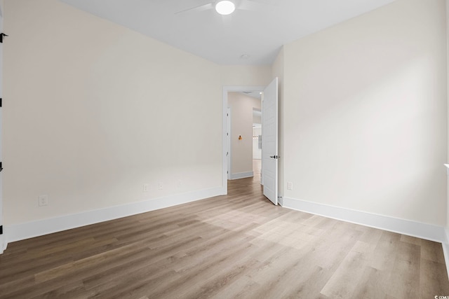 unfurnished room with baseboards, a ceiling fan, and light wood-style floors