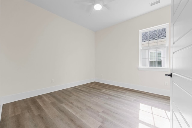 spare room featuring visible vents, ceiling fan, light wood-style flooring, and baseboards