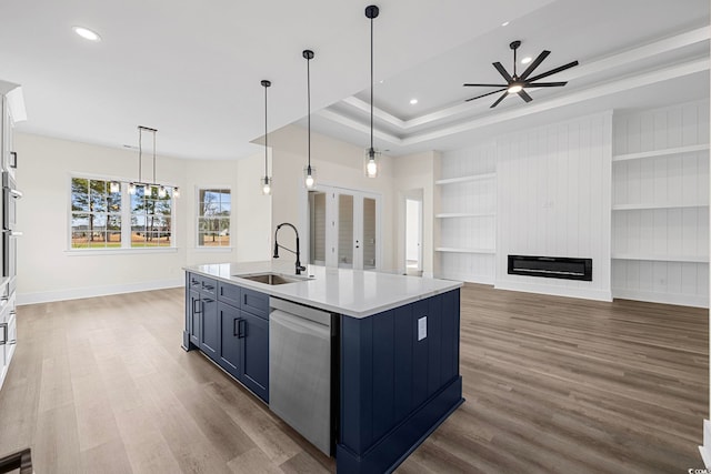 kitchen featuring stainless steel appliances, a sink, open floor plan, an island with sink, and decorative light fixtures