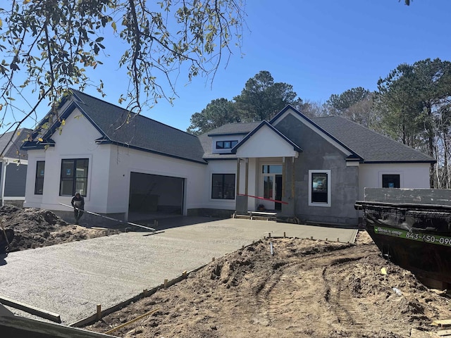 view of front facade with a garage, roof with shingles, concrete driveway, and stucco siding