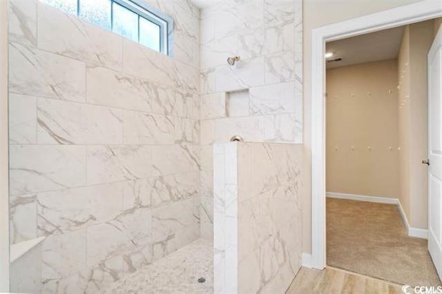 bathroom featuring a tile shower and hardwood / wood-style floors