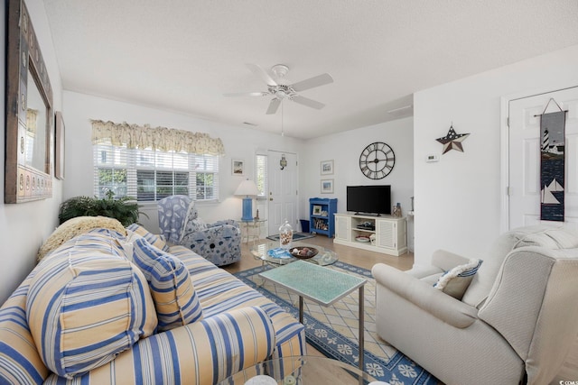 living room with a textured ceiling, wood-type flooring, and ceiling fan