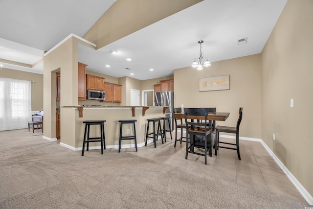 dining space with light carpet and a notable chandelier