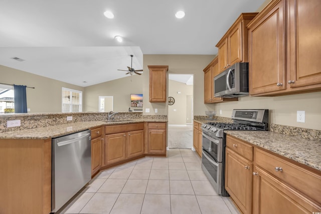 kitchen featuring ceiling fan, sink, vaulted ceiling, light tile patterned floors, and appliances with stainless steel finishes