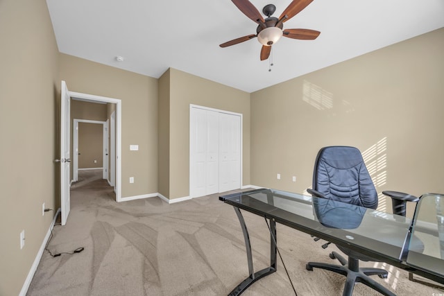 carpeted office with a ceiling fan and baseboards