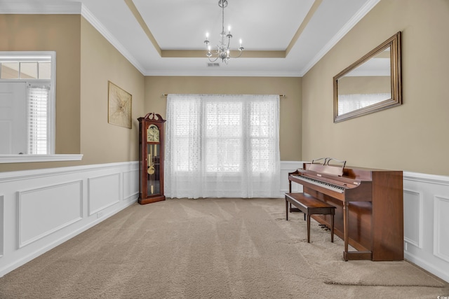 miscellaneous room featuring a tray ceiling, light carpet, plenty of natural light, and a chandelier