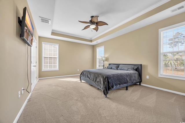 carpeted bedroom featuring a tray ceiling, ceiling fan, and ornamental molding