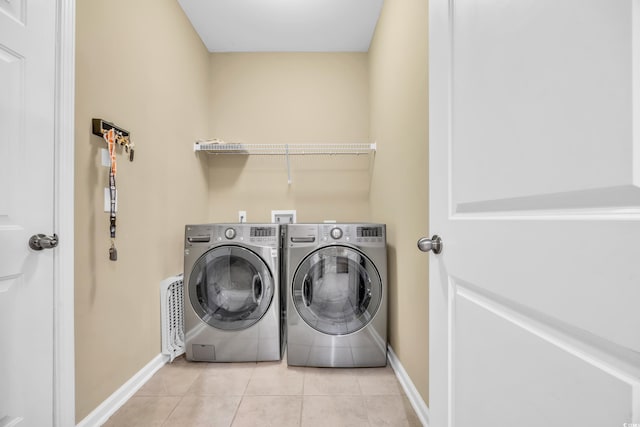 washroom with independent washer and dryer and light tile patterned floors