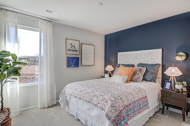 carpeted bedroom featuring visible vents and baseboards