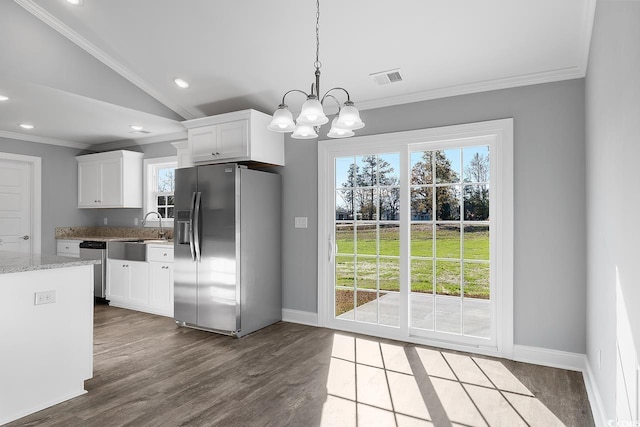 kitchen featuring white cabinetry, lofted ceiling, a chandelier, hanging light fixtures, and stainless steel appliances