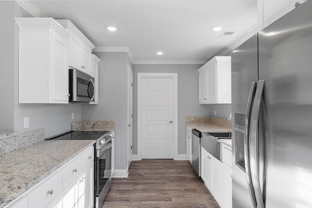 kitchen with crown molding, appliances with stainless steel finishes, white cabinets, and light stone counters