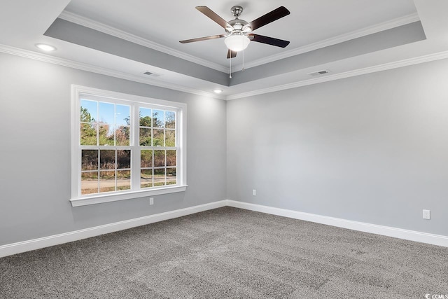 carpeted spare room featuring a tray ceiling, ornamental molding, and ceiling fan