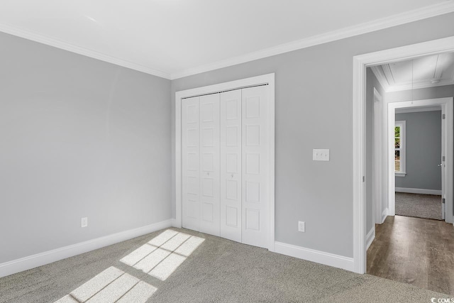 unfurnished bedroom with ornamental molding, carpet floors, and a closet