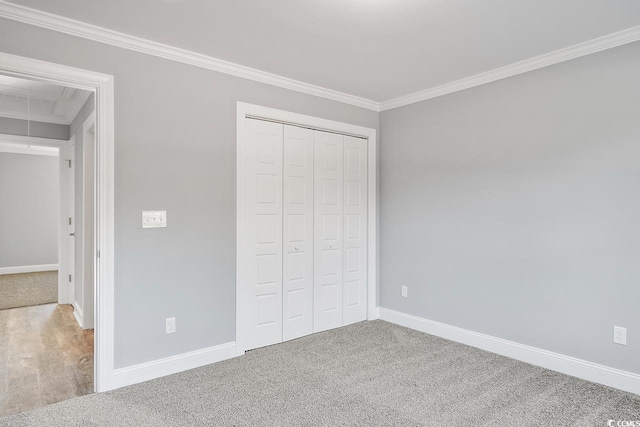 unfurnished bedroom with crown molding, carpet floors, and a closet