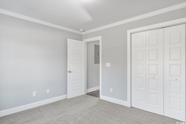 unfurnished bedroom with crown molding, carpet floors, electric panel, and a closet