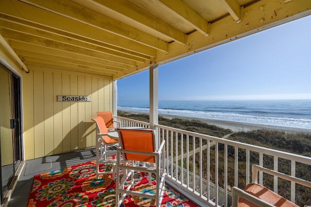 balcony featuring a beach view and a water view