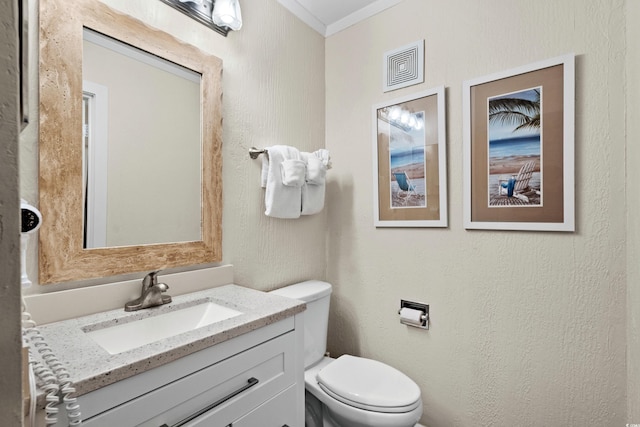 bathroom featuring vanity, toilet, and crown molding