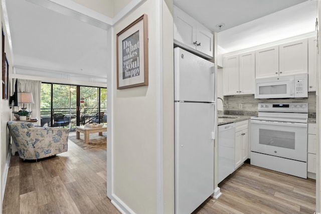 kitchen with white appliances, backsplash, sink, light wood-type flooring, and white cabinetry