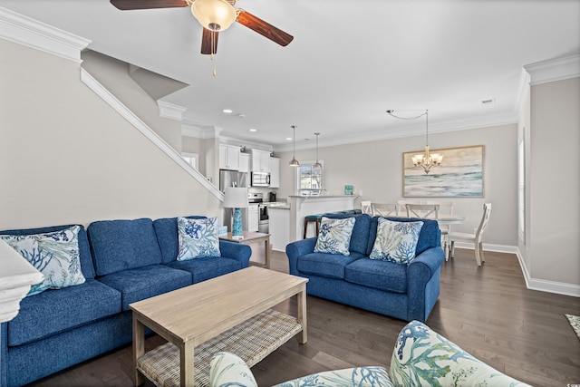 living room featuring dark hardwood / wood-style flooring, crown molding, and ceiling fan with notable chandelier