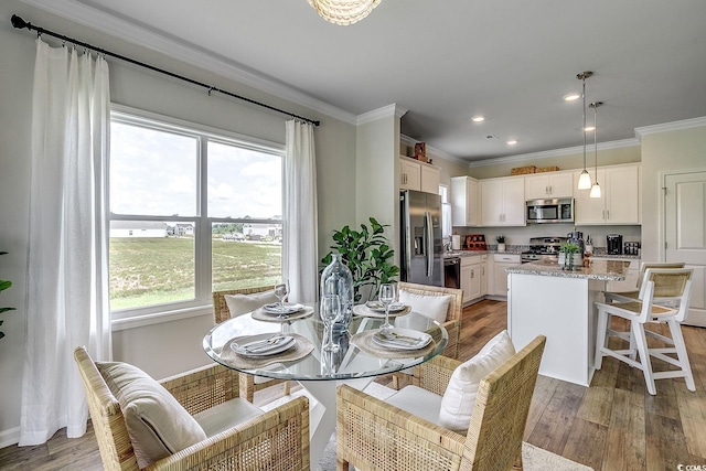 dining space with crown molding and light hardwood / wood-style flooring