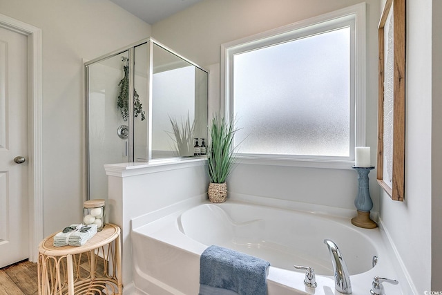 bathroom with independent shower and bath and hardwood / wood-style flooring