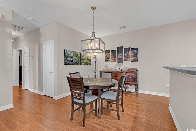 dining space with a chandelier and light wood-type flooring