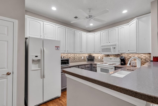 kitchen with tasteful backsplash, light hardwood / wood-style flooring, white cabinets, and white appliances