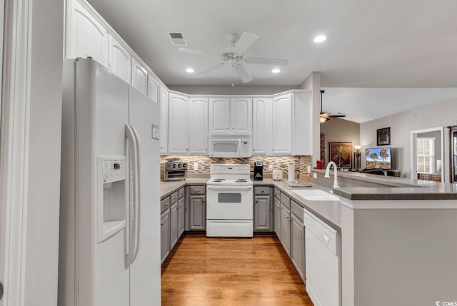 kitchen featuring ceiling fan, sink, kitchen peninsula, white appliances, and light wood-type flooring