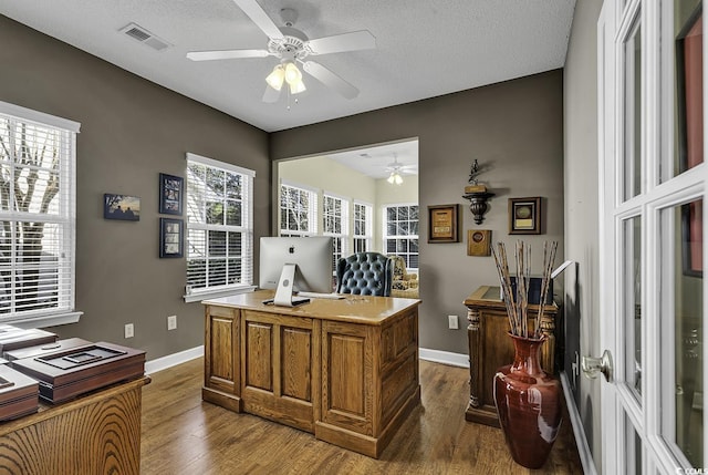 office with a textured ceiling and dark wood-type flooring