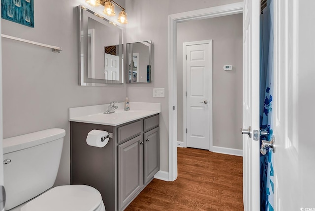 bathroom featuring vanity, wood-type flooring, and toilet