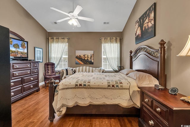 bedroom with multiple windows, ceiling fan, hardwood / wood-style floors, and lofted ceiling