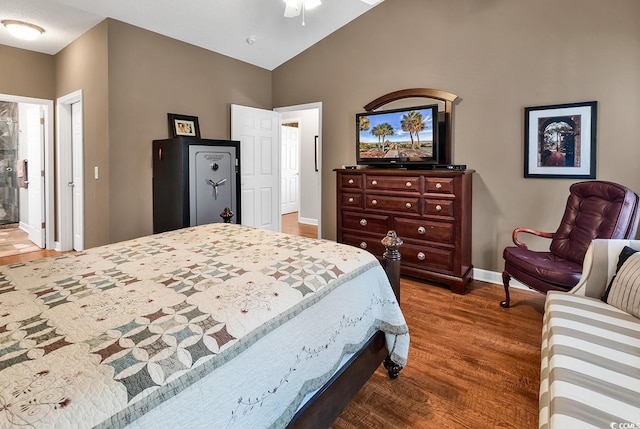 bedroom featuring ensuite bathroom, dark wood-type flooring, and vaulted ceiling